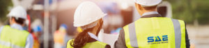 Man and woman in SAE fluorescent yellow vests and White hardhats | SAE Inc.