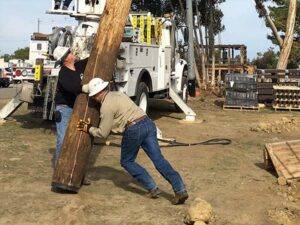 men installing electrical pole